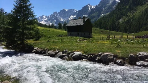 Mountain river flowing next to an house Stock Footage 112221579