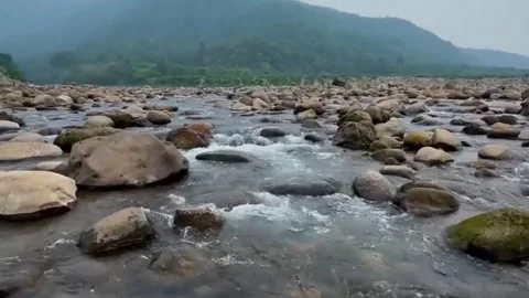 Mountain River Flowing Over Rocks with Lush Green Hills Landscape Stock Footage 333545028
