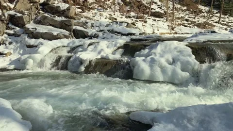 Mountain river flowing rapidly covered with snow Stock Footage 157592608