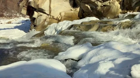 Mountain river flowing rapidly through snowy winter landscape Video stock 342647437