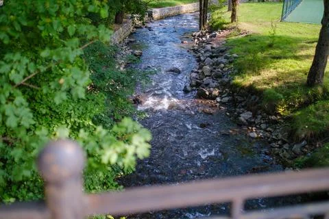 Mountain river flowing through forest park viewed from bridge Фото