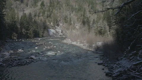 Mountain river flowing through a snowy forest wilderness Stock Footage 331660680