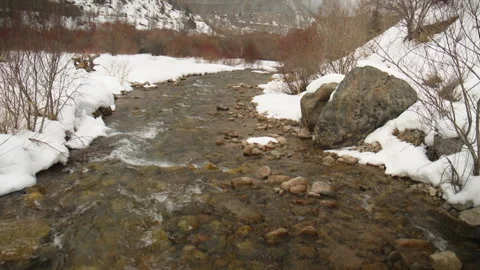 Mountain river flowing through a snowy winter landscape Видео 331800538