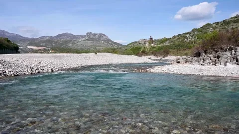 A mountain river flows. Clean water. A stone thrown into the water. Stock Footage 307647766