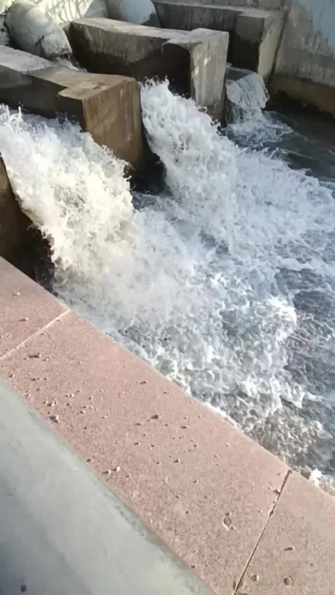 A mountain river flows out of pipes into a concrete channel. 库存影片 336090391