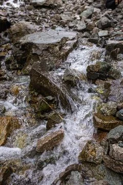 The mountain river flows quickly over the stones Stock Photos