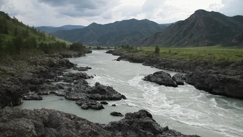 The mountain river flows in solidified, petrified lava. The mountains. Vídeos de archivo 119995847