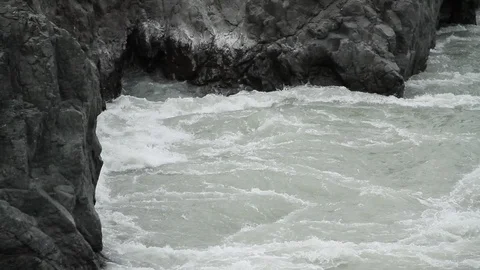 The mountain river flows in solidified, petrified lava. The mountains. 스톡 동영상 119995866