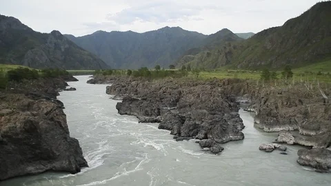 The mountain river flows in solidified, petrified lava. The mountains. 動画素材 119995893