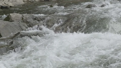 Mountain river flows in strong stream slow motion. Abundant water flow of Stock Footage 200735340