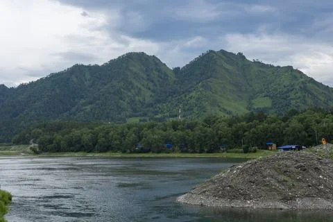 Mountain river flows surrounded by green mountains Stock Photos