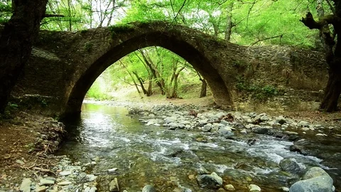 Mountain river flows under the medieval venetian bridge Stock Footage 70497291