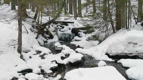 A mountain river, icicles hanging over the stream and a lot of snow. Mountain Stock Footage 274252393