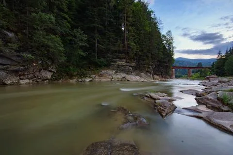 Mountain river with large stones at the foot of the mountain at sunset, lon.. Stock Photos