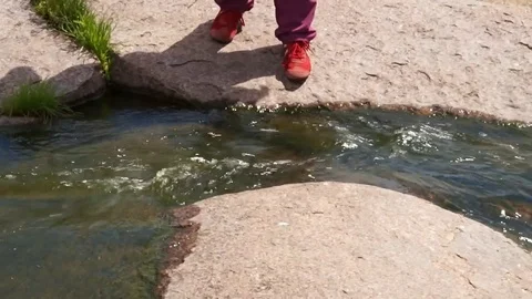 Mountain river. The man jumped over a stream. Video stock 103848235