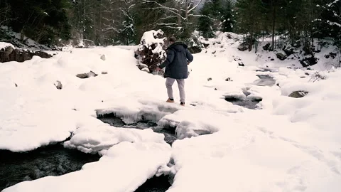 Mountain river. A man jumps over a mountain river. Stock Footage 154332616