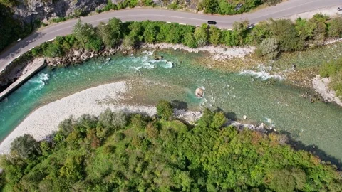 A mountain river in a mountain gorge, a black car is driving along the road Vidéo 256167592
