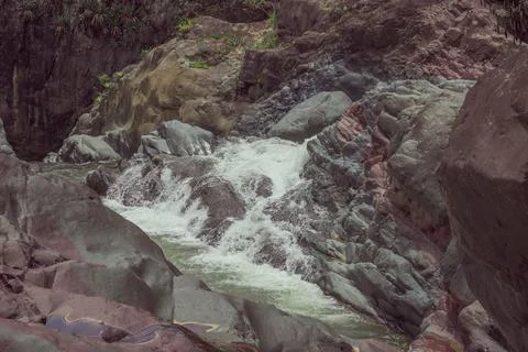 Mountain river, rapid current, red, yellow and gray boulders Stock Photos
