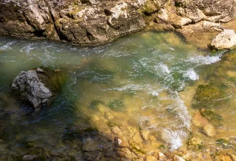 A mountain river with a rapid flow and an unusual stone bed and waterfalls in Stock Photos