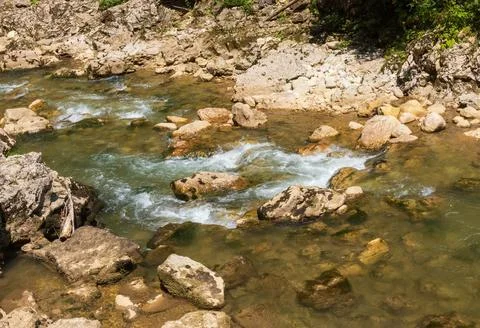 A mountain river with a rapid flow and an unusual stone bed and waterfalls in Stock Photos