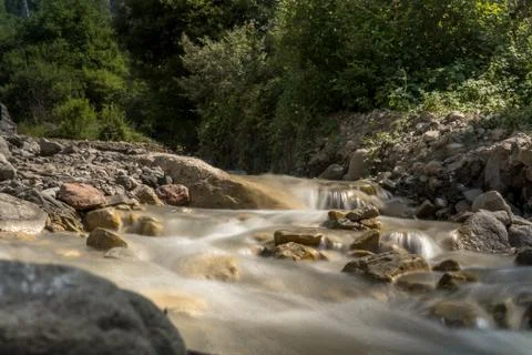 Mountain river with Rapid stream and with bright blurred waves. Big mossy Stock Photos