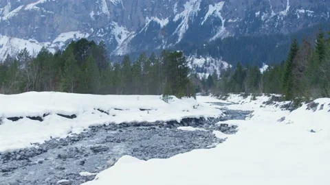 Mountain river with rocks crossing the snowy forest in the Alps, in Switzerland Stock Footage 239748186