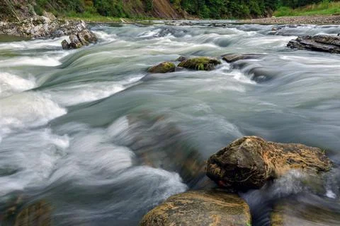 Mountain river with rocks at a long exposure from the bottom of the photograp Stock Photos
