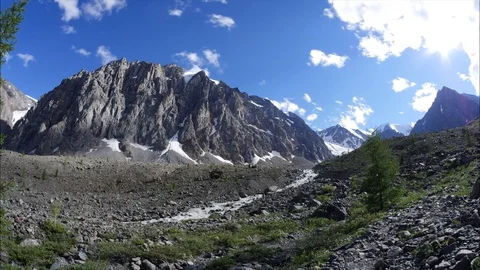 The mountain river is running along the valley. The steep mountain. View of the Stock Footage 108585959