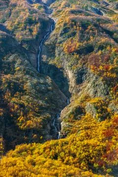 Mountain river running down the mountain among the autumn cliffs Stock Photos