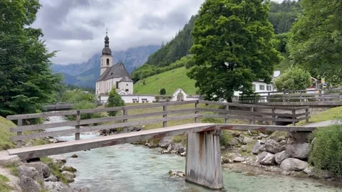 Mountain river runs through Ramsau town. Parish Church of St. Sebastian. Germany Video stock 341423534