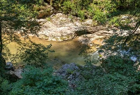 A mountain river with a rushing stream and waterfalls in the warm season in n Stock Photos