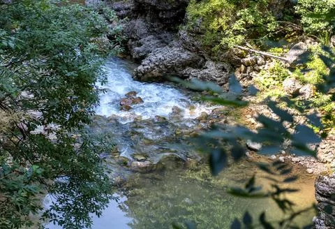 A mountain river with a rushing stream and waterfalls in the warm season in n Stock Photos