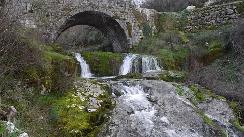 Mountain river slope under an old bridge Stock Footage 86953545