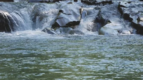 Mountain River with Small Waterfall Flowing Over Smooth River Rocks Stock Footage 340035744