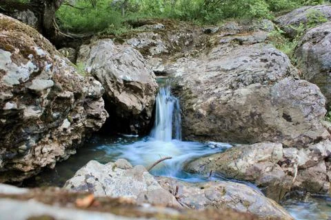 Mountain river - a small waterfall on a river with crystal clear water that Fotos de archivo