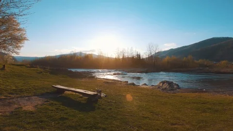Mountain river at sunset. Walks along the beach towards the water and dives Stock Footage 106511222