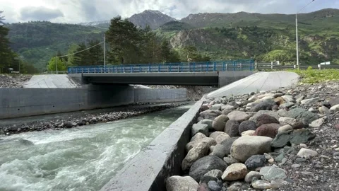 Mountain River. Trees. Green Grass. Stones. Mountains. Bridge 01 Stock Footage 155619623