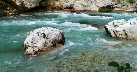 Mountain river with turquoise water flows among large stones Stock Footage 247509315