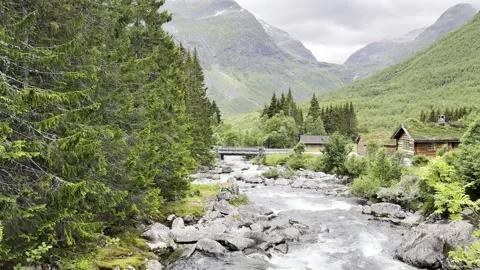 Mountain river under bridge and grass roof houses Vidéo 340238153