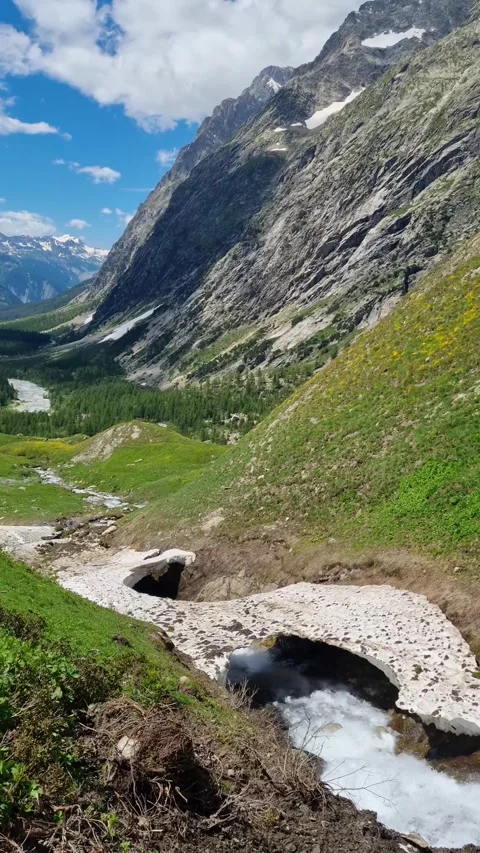 A mountain river in the Val Ferre valley in Italy with a rocky mountain range Video stock 284668458
