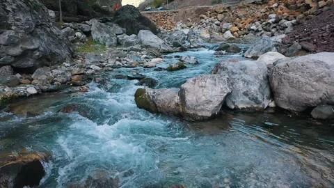 Mountain river, water flows down the stones turning into a stream Stock Footage 249282273
