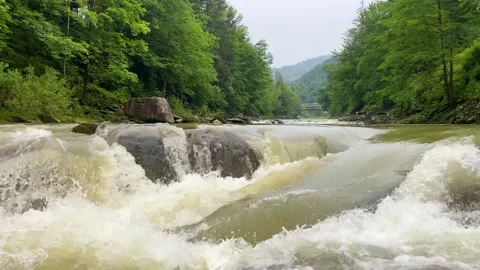 Mountain river water surface in slow motion. Clear stream making waves in Stock Footage 252648810