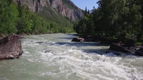 Mountain river in the wild. A stream of water flowing through stone boulders Stock Footage 247574207