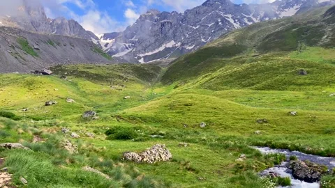 A mountain river winds through Juta Valley beneath Mount Chaukhi Stock Footage 340388373