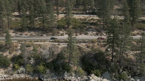 Mountain road along crystal clear lake cinematic footage Stock Footage 163685653