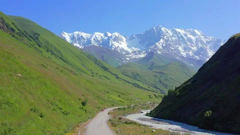 Mountain road approaches in forward aerial view along the Enguri valley toward Vídeo Stock 344143525