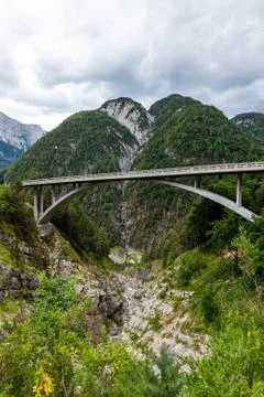 Mountain road with bridge spanning over a gorge in European Alps with mountain Stock Photos