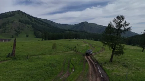 Mountain road with a car in the frame; forest and mountains in the background. Stock Footage 345184684