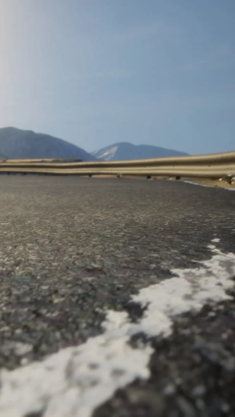 Mountain road curves gently under clear sky with distant peaks 動画素材 336430622
