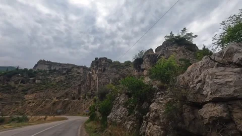 Mountain road curves in wide view through rugged rock formations in Turkey Stock Footage 343805145